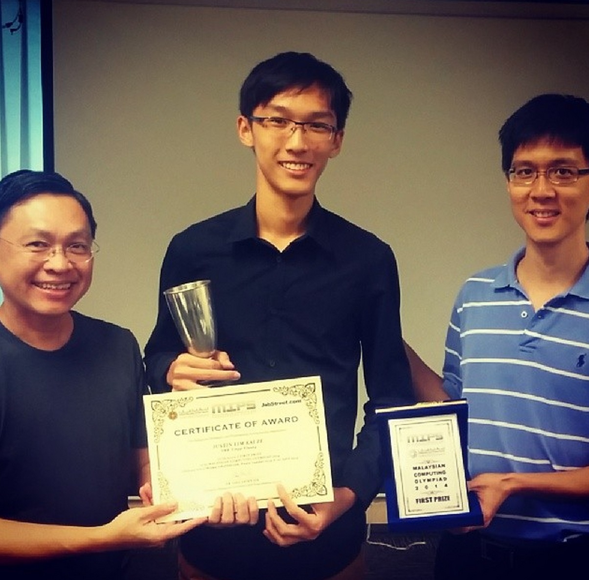 Justin Lim receiving the MCO Challenge Trophy from Mr Mark Chang and Dr Ong Shien Jin.