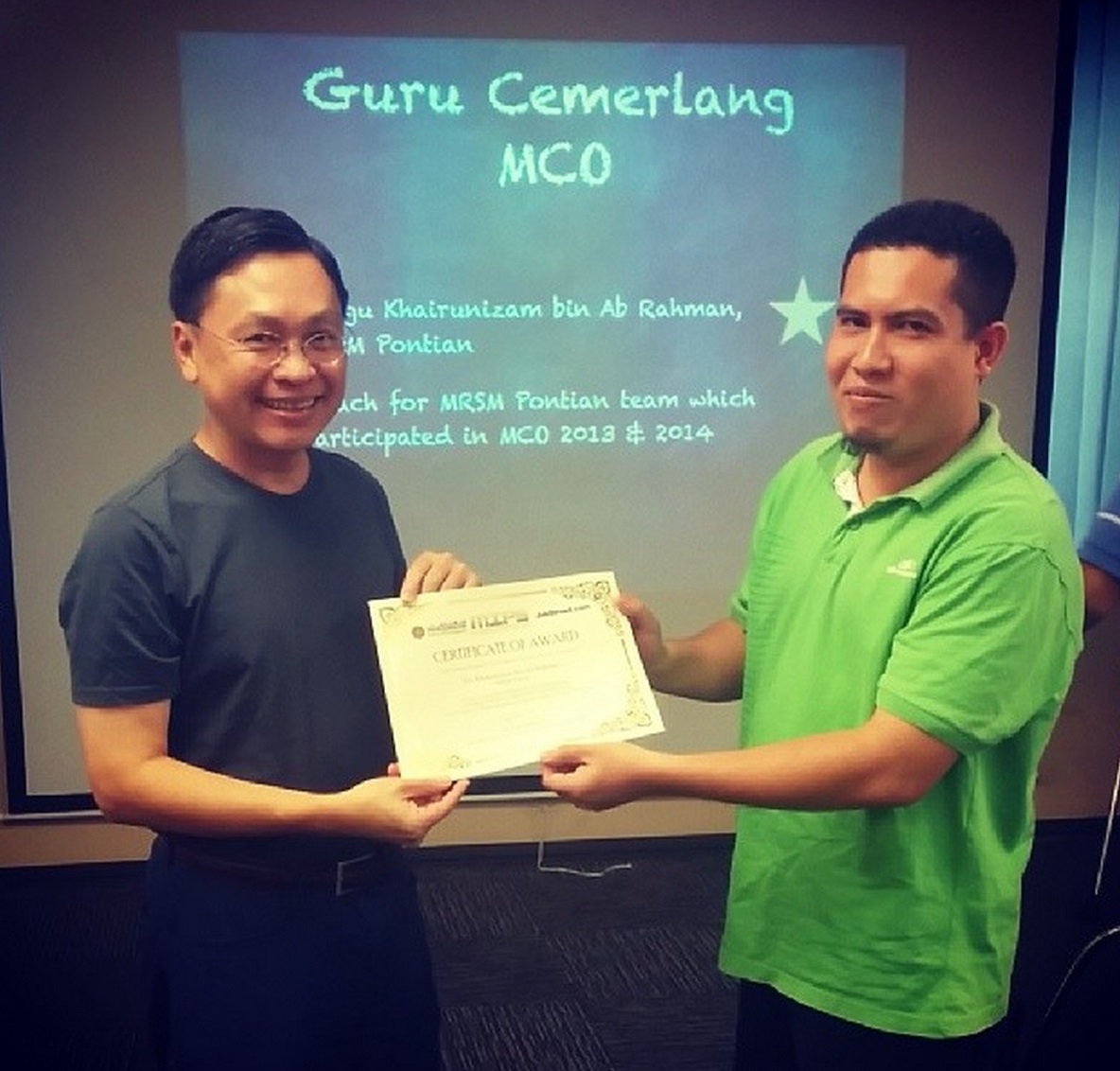 Mr Mark Chang presenting Cikgu Khairunizam from MRSM Pontian with the 'Guru Cemerlang MCO' award.